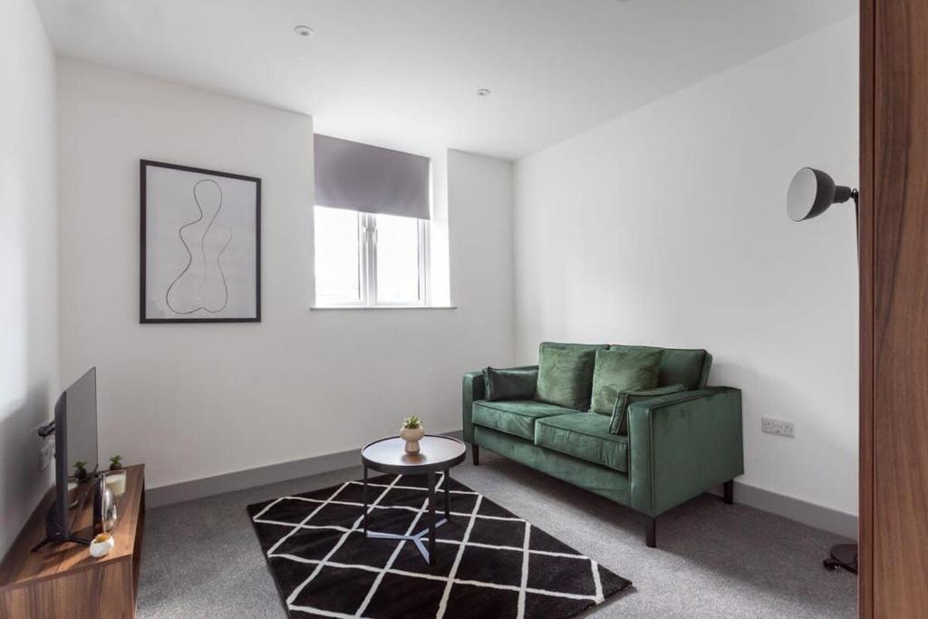 a living room with a green couch and a table at Modern 1 Bedroom Apartment Leeds in Leeds