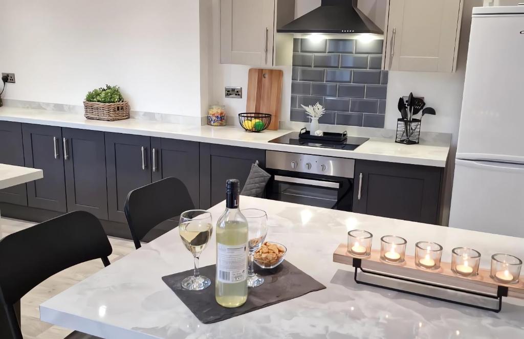 a kitchen with a table with a bottle of wine and glasses at Ferrers House in Doncaster