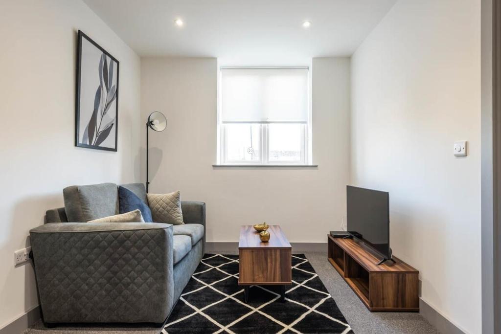 a living room with a couch and a tv at Lovely Compact 1 Bed Apartment in Leeds in Leeds