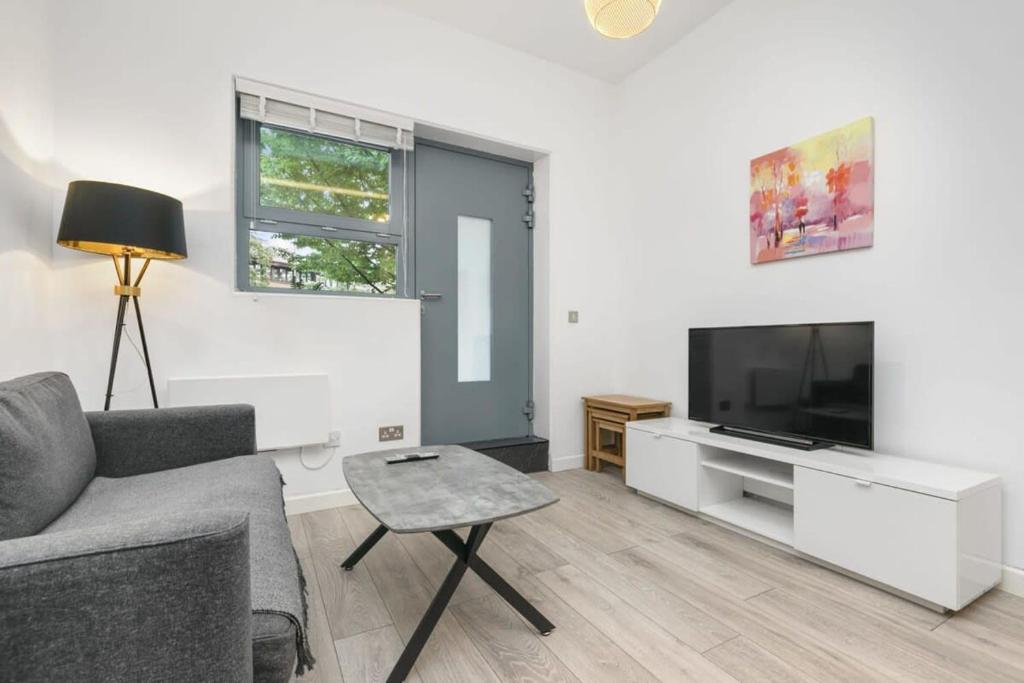 a living room with a couch and a tv at Modern 1 Bedroom Apartment in Central Woking in Woking