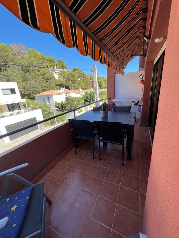 un balcón de una casa con mesa y sillas en AP21-Sa Riera en Begur