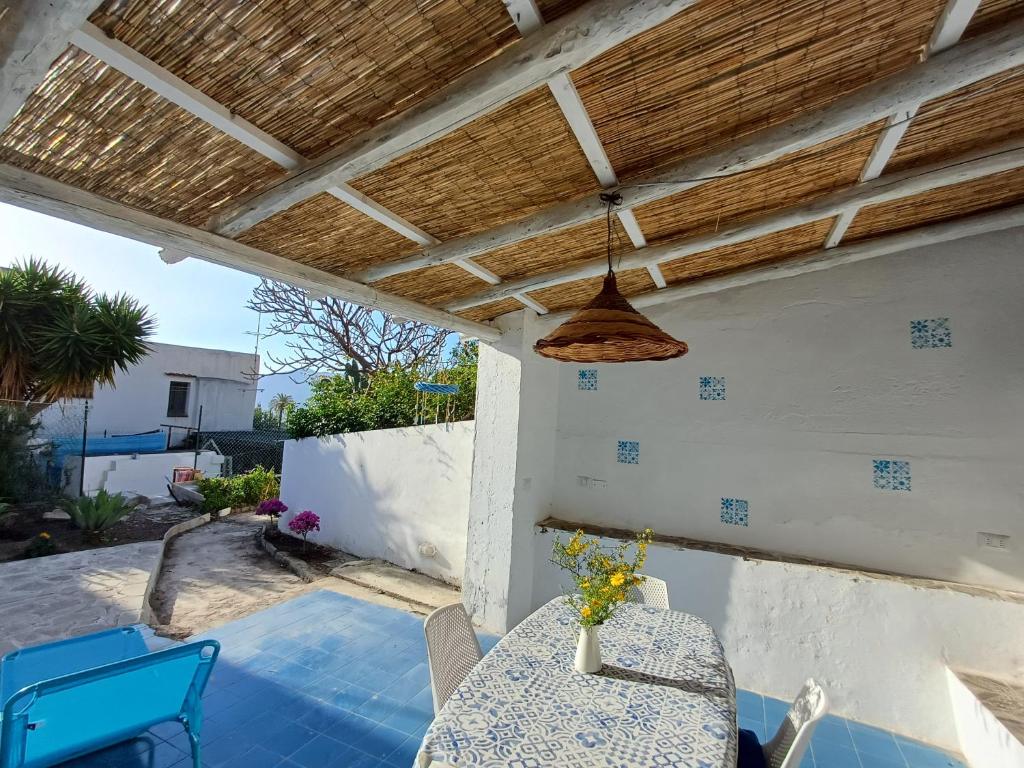 un patio con mesa, sillas y techo de madera. en da Massimo, en Santa Marina Salina