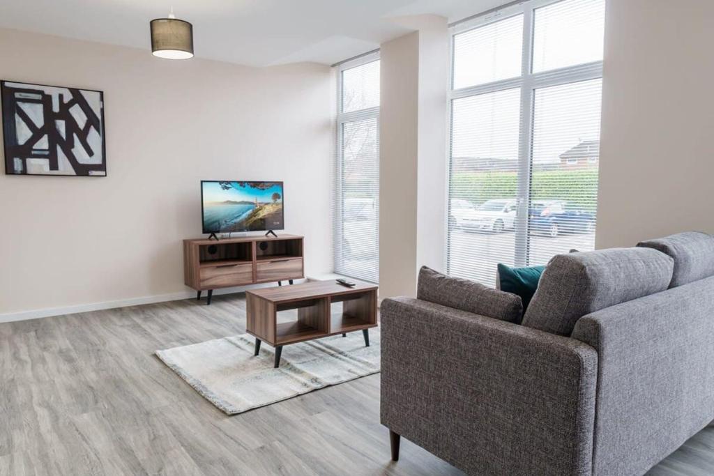 a living room with a couch and a tv and a table at Fantastic 1 Bed Apartment Manchester - Sleeps 2 in Manchester