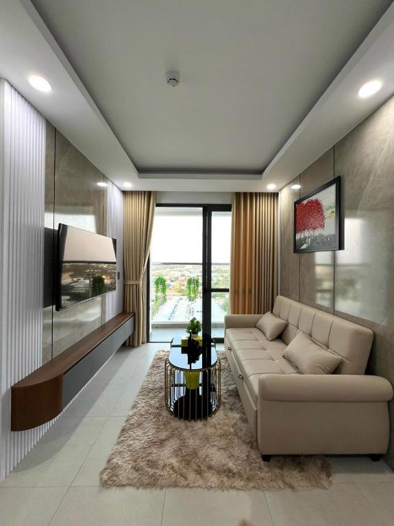 ein Wohnzimmer mit einem Sofa und einem TV in der Unterkunft Căn hộ 2 phòng ngủ tầng 10 chung cư cao cấp Sophia Center in Ấp Rạch Mẹo