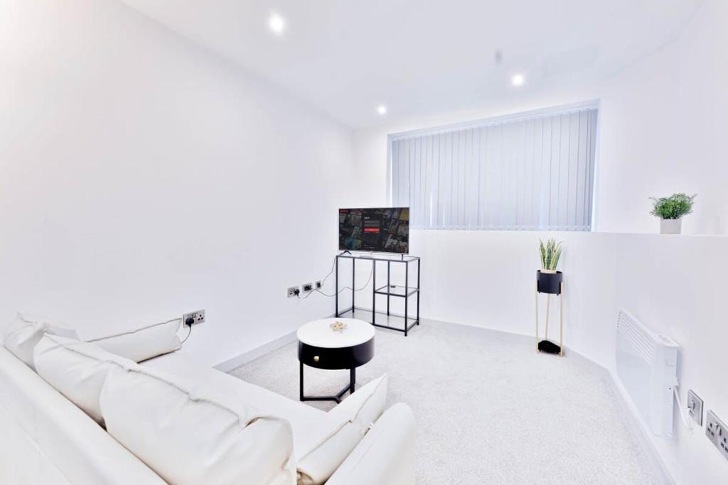 a white living room with a white couch and a tv at Modern 1 Bed Apartment in Central Wolverhampton in Wolverhampton