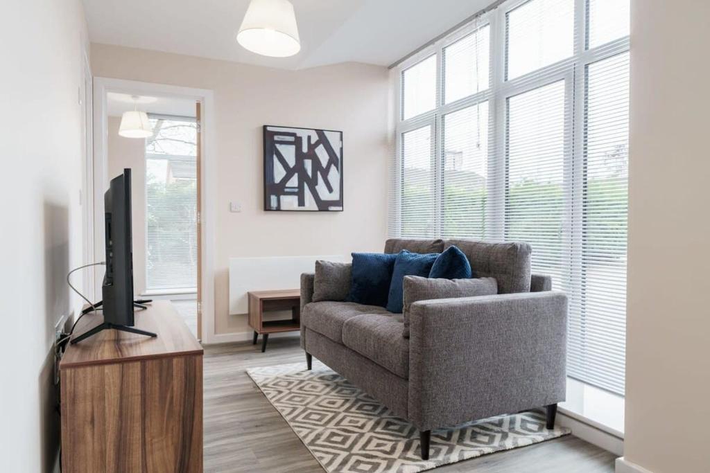 uma sala de estar com um sofá e uma televisão em Bright 1 Bed Apartment Manchester - Sleeps 2 em Manchester