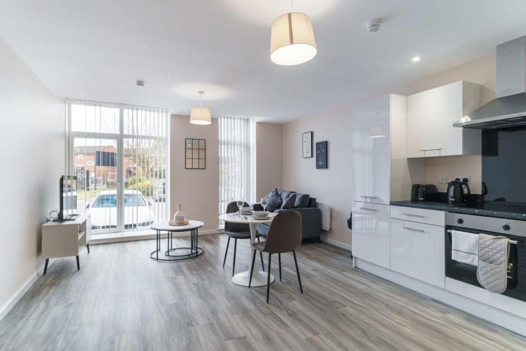 een keuken en een woonkamer met een tafel en stoelen bij Modern 1 Bedroom Apartment Manchester - Sleeps 2 in Manchester