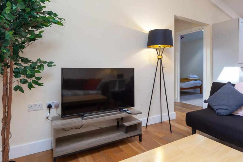 a living room with a flat screen tv on a stand at Modern 2 Bed Attic Apartment in Brixton in London