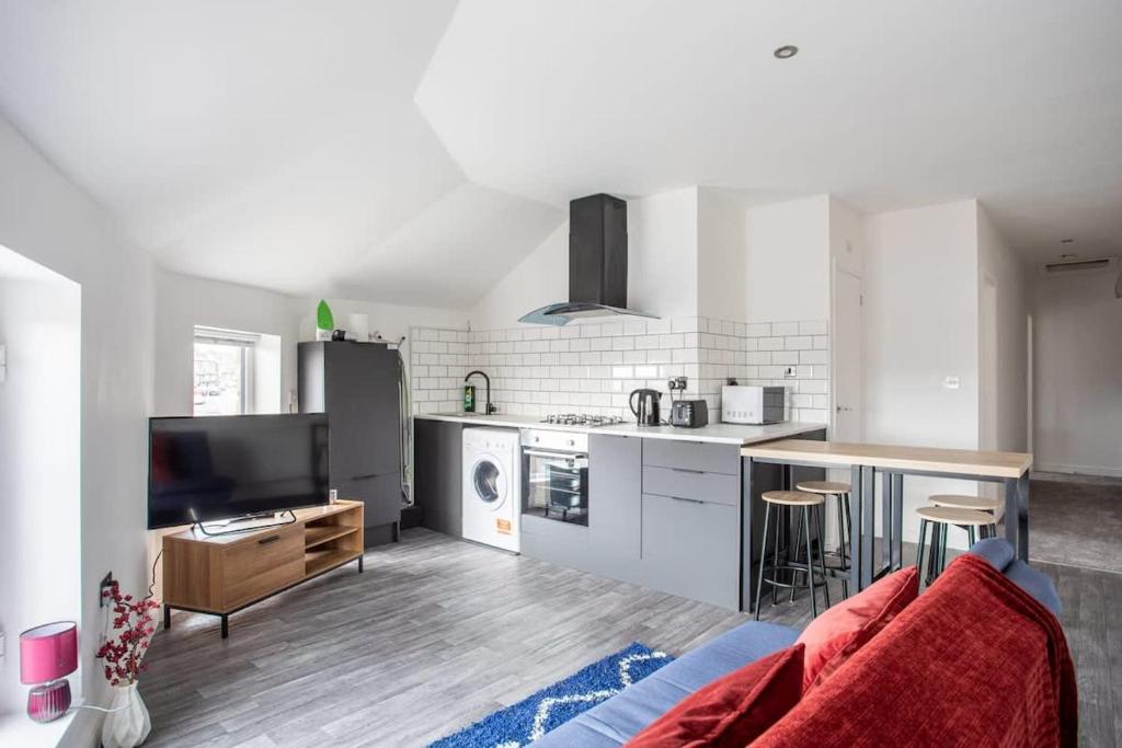 2 Bed Apartment Close to Bradford City Centre في برادفورد: غرفة معيشة مع أريكة ومطبخ