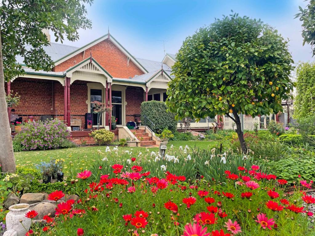 una casa con un jardín con flores en el patio en Gold and Grapes Garden Suites, en Rutherglen