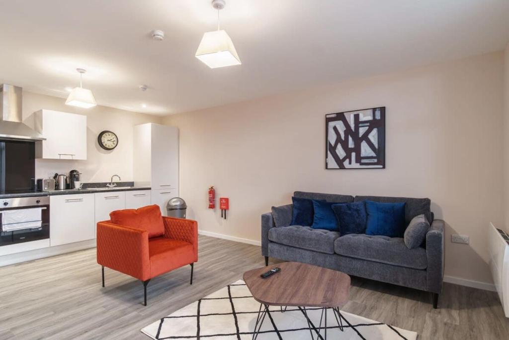ein Wohnzimmer mit einem Sofa und einem Tisch in der Unterkunft Bright 2 Bed Apartment Manchester - Sleeps 4 in Manchester