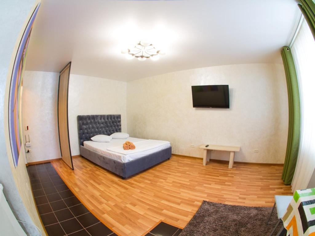 a bedroom with a bed and a tv in a room at Павлова 64, 1 комнатная комфорт класса в центре от компании Home Hotel in Kostanay