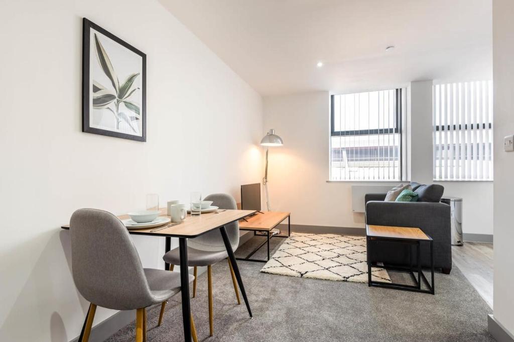 a living room with a table and chairs at Lovely Studio Apartment in Central Wakefield in Wakefield