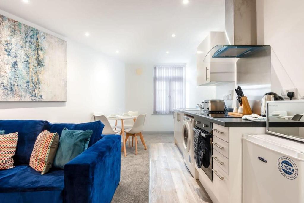 a living room with a blue couch in a kitchen at Modern Budget Apartment in Central Doncaster in Doncaster