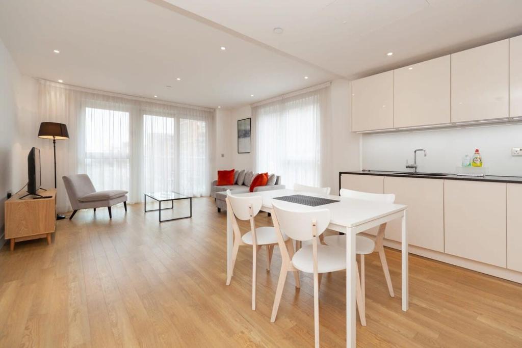 a kitchen and living room with a table and chairs at Modern 2 Bed Apartment in South Lambeth in London