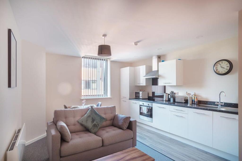 uma sala de estar com um sofá e uma cozinha em Contemporary 1 Bed Manchester Apartment em Manchester