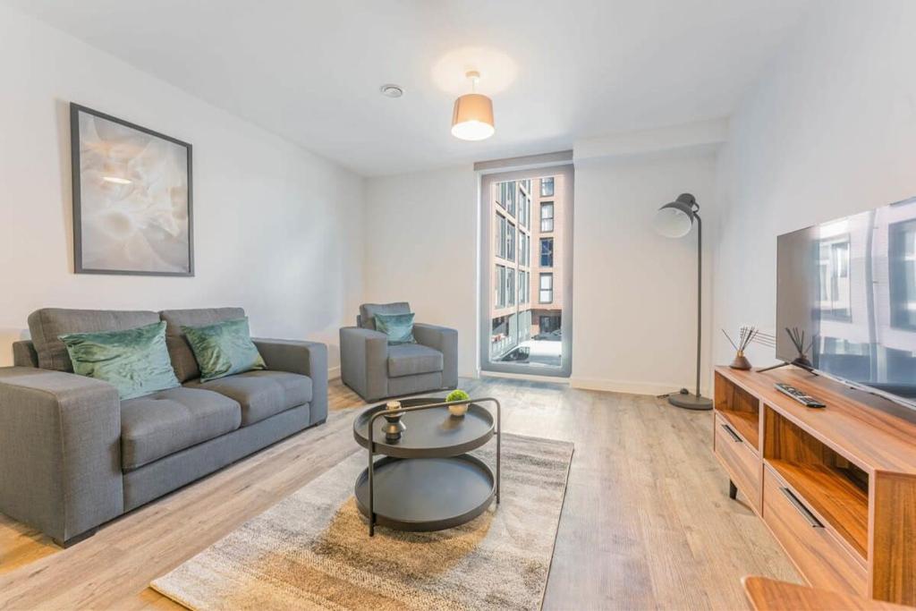 a living room with a couch and a table at Central Birmingham 1 Bedroom Apartment in Birmingham