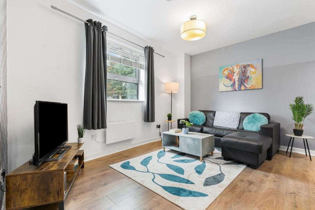 a living room with a couch and a tv at Spacious 1 Bedroom Apartment in Central Woking in Woking