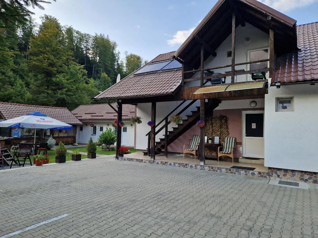 a house with a balcony and a patio at Casa Popa’s in Cârțișoara