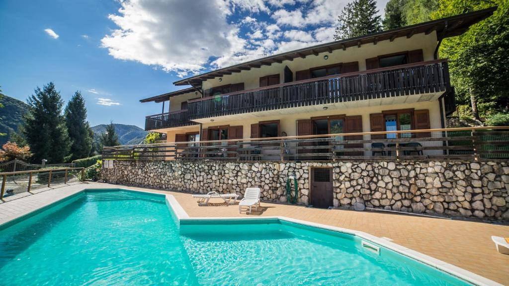 a villa with a swimming pool in front of a house at Residence Panorama in Molina di Ledro