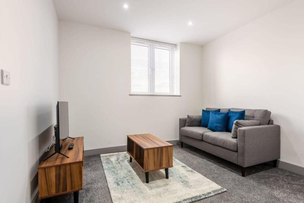 Smart 1 Bedroom Apartment in Leeds في ليدز: غرفة معيشة بها أريكة وتلفزيون