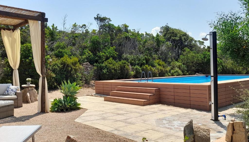 a swimming pool in a yard with a patio at Ferienhaus Casa Oliva - Villaggio Galanu in Costa Paradiso