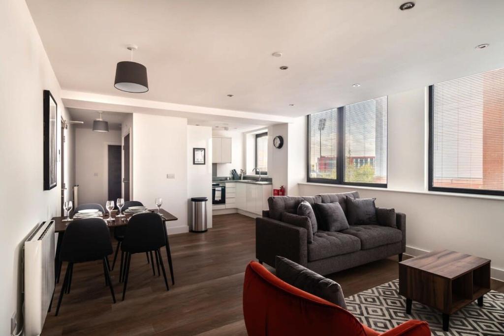 Modern & Spacious 2 Bed Apartment by Old Trafford في مانشستر: غرفة معيشة مع أريكة وطاولة