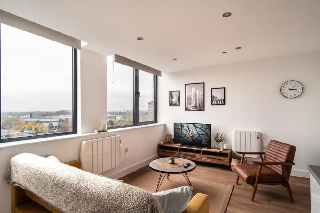 ein Wohnzimmer mit einem Sofa und einem Tisch in der Unterkunft Sleek 1 Bedroom Apartment by Old Trafford in Manchester