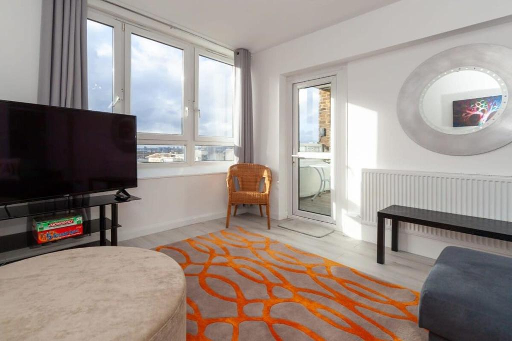 a living room with a flat screen tv and a couch at 3 Bedroom Old Street Apartment - Amazing Views in London