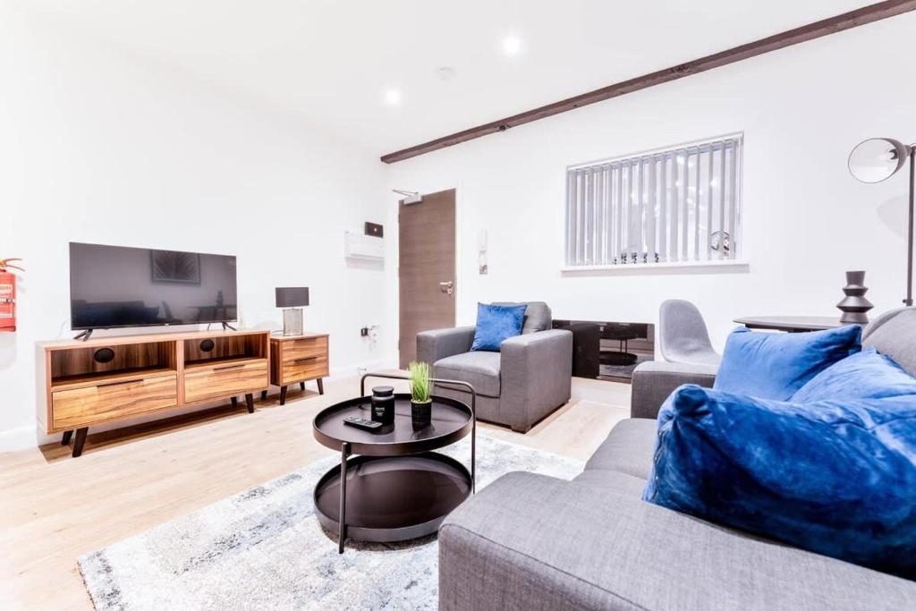 ein Wohnzimmer mit einem Sofa und einem TV in der Unterkunft Beautiful 1 Bed Apartment in Burton-on-Trent in Burton upon Trent