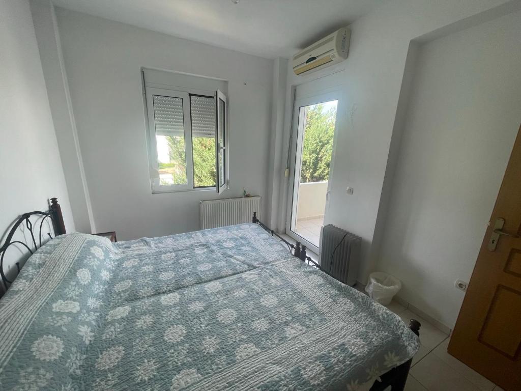 um quarto com uma cama e uma janela em Centrum Almyrida Apt em Almirída