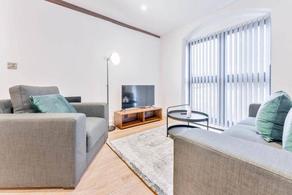 a living room with two couches and a television at Stylish 2 Bed Apartment in Burton-on-Trent in Burton upon Trent