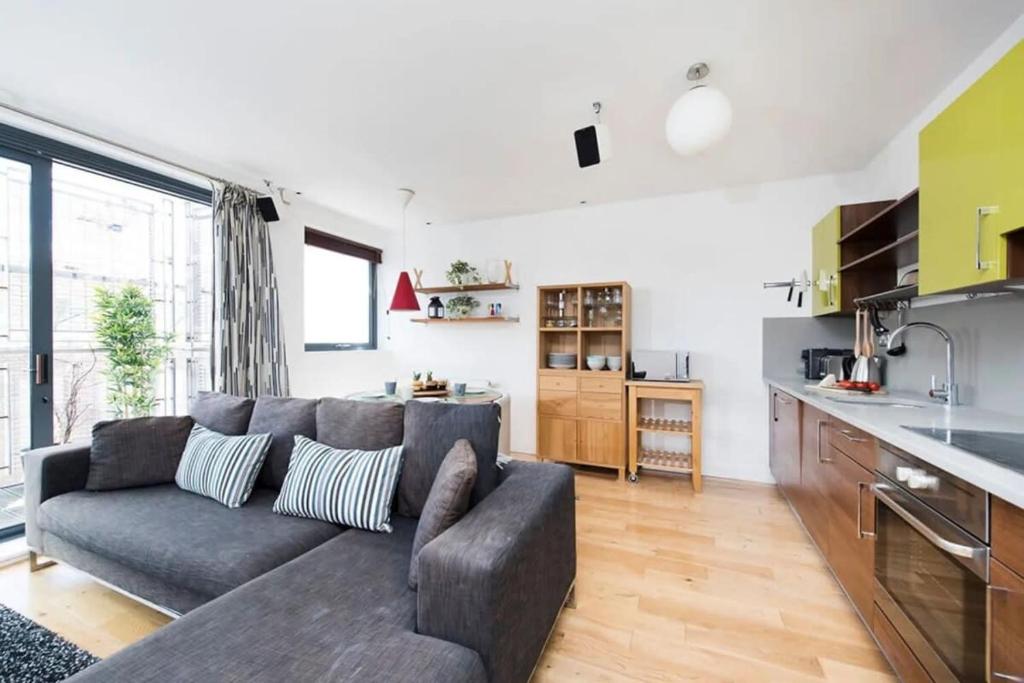 sala de estar con sofá y cocina en Modern 2 Bed Apartment w Balcony in London en Londres