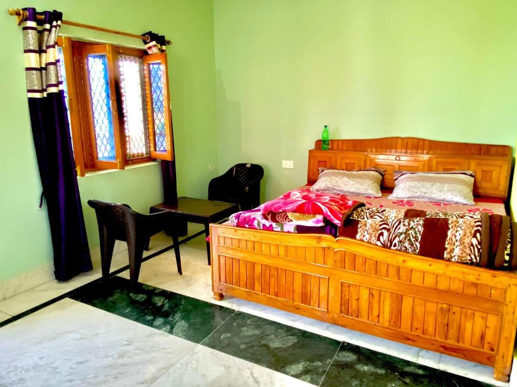 Himdarshan Homestay في Jageshwar: غرفة نوم بسرير خشبي وطاولة