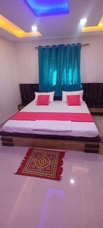 a bedroom with a large bed with a blue curtain at Hotel Raxaul King in Raxaul