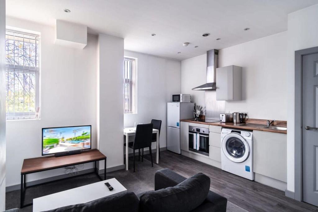 un soggiorno con divano e tavolo e una cucina di Smart 1 Bedroom Apartment in Blackburn a Blackburn