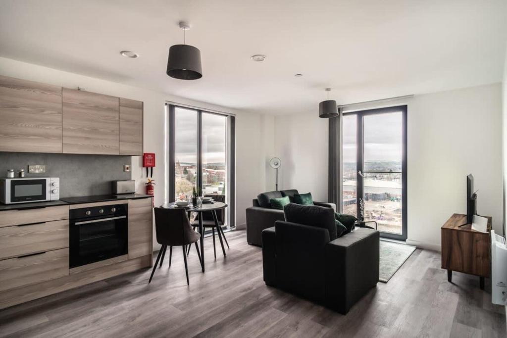 eine Küche und ein Wohnzimmer mit einem Sofa und einem Tisch in der Unterkunft Smart 1 Bedroom Apartment in Central Preston in Preston