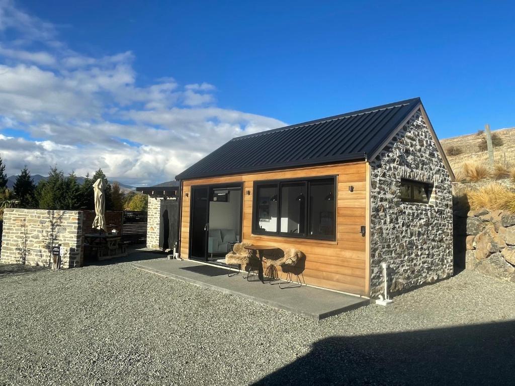 a small cabin with a stone wall at Simply Stunning Studio 2 in Lake Tekapo