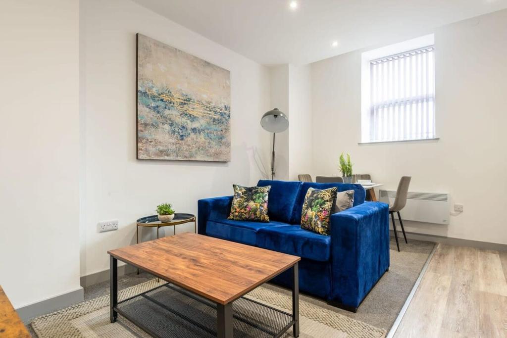 a living room with a blue couch and a table at Smart 2 Bed Budget Apartment in Central Doncaster in Doncaster