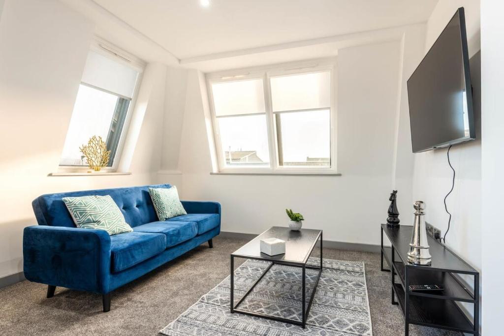 a living room with a blue couch and a tv at Modern 1 Bedroom Apartment in Central Hull in Hull