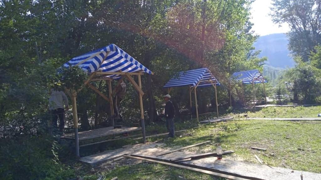 a group of blue and white umbrellas in a yard at САЙ-SAI in Arslanbob