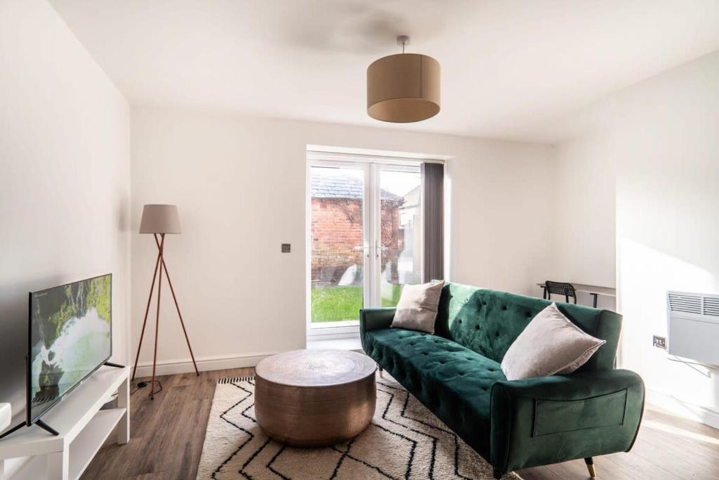 - un salon avec un canapé vert et une table basse dans l'établissement Modern 2 Bed Apartment in Waterloo Liverpool, à Liverpool