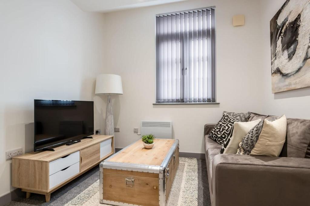 a living room with a couch and a tv at 1 Bedroom Budget Apartment in Central Doncaster in Doncaster