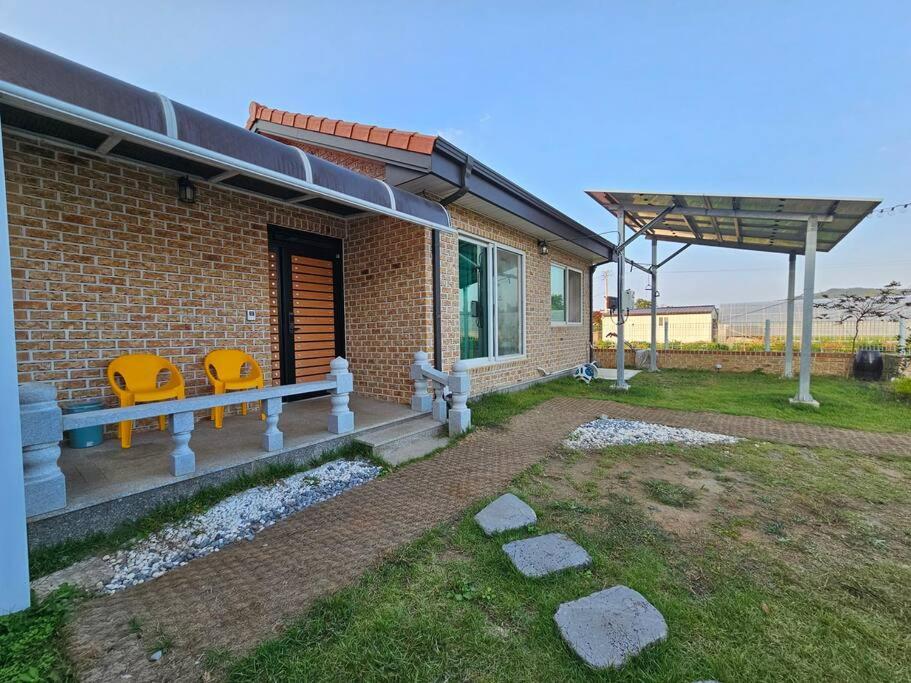 a brick house with two yellow chairs on a porch at 2022 New Entire house for family in Boseong