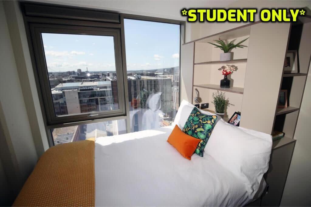 a bedroom with a white bed and a large window at Student Only Zeni Ensuite Rooms Belfast in Belfast