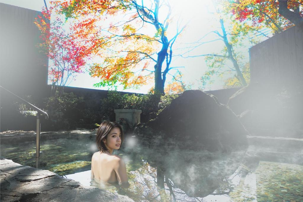 a woman sitting in a bath tub with steam at Resort Hotel RAKI House Nasu in Nasu