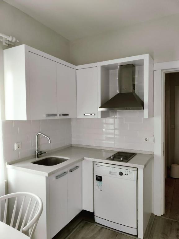 a white kitchen with a sink and a stove at Port Hotel, Tasucu in Silifke