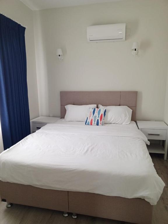 a bedroom with a white bed with a pillow on it at Port Hotel, Tasucu in Silifke