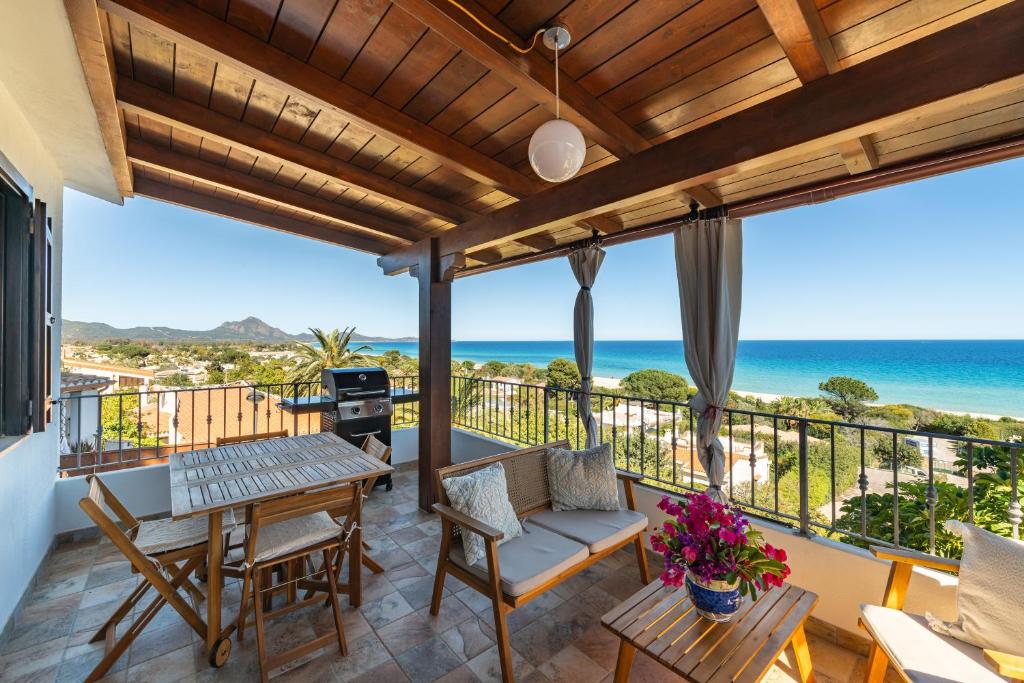 einen Balkon mit einem Tisch, Stühlen und Meerblick in der Unterkunft Casa Mariano in Costa Rei