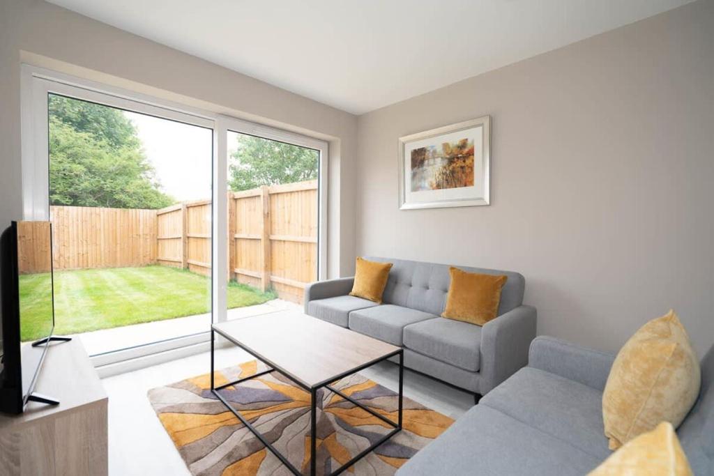 a living room with a couch and a large window at Cosy 3 Bedroom Home in Birmingham with Garden in Birmingham